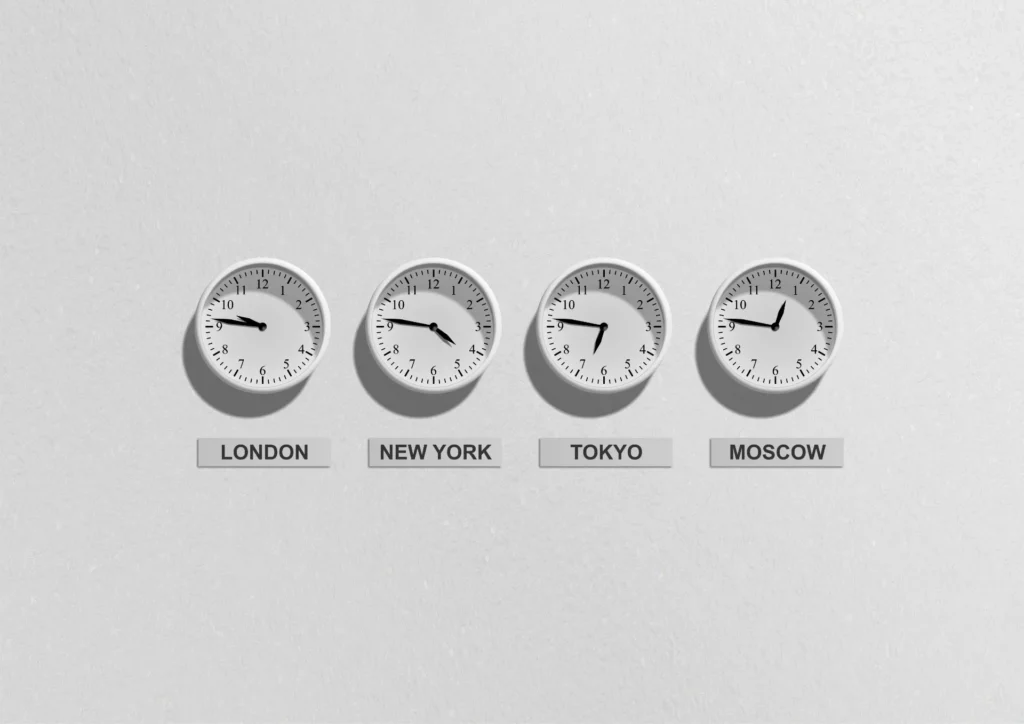 four wall clocks with different time zones
